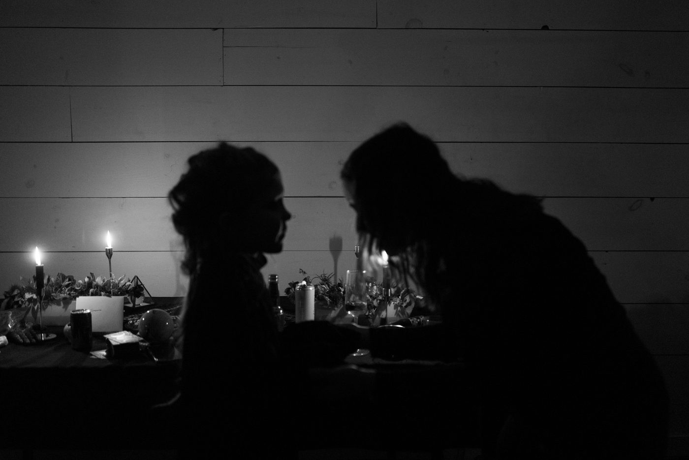 Two children whisper in silhouette 