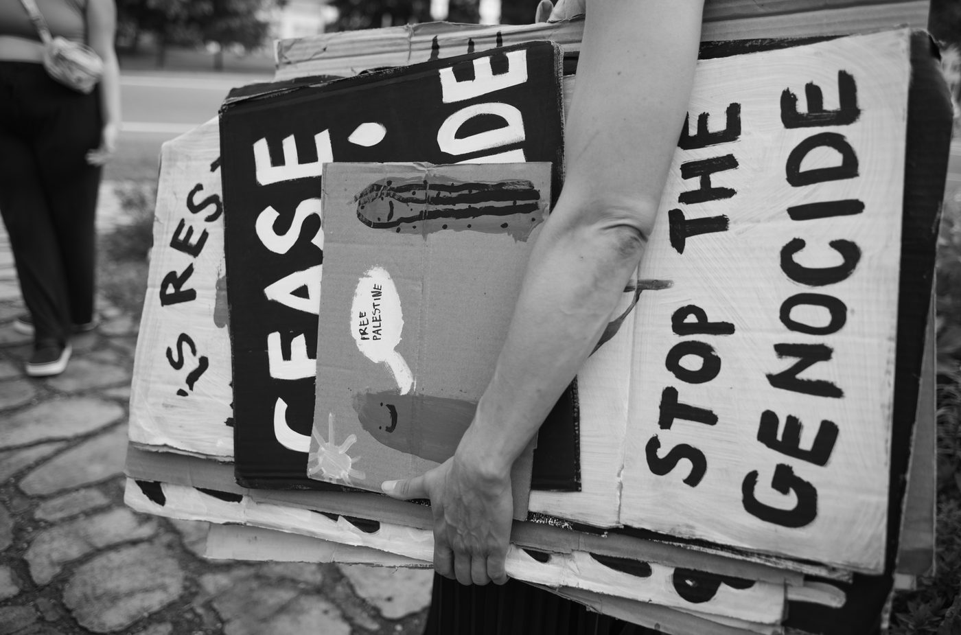 A person holds protest signs
