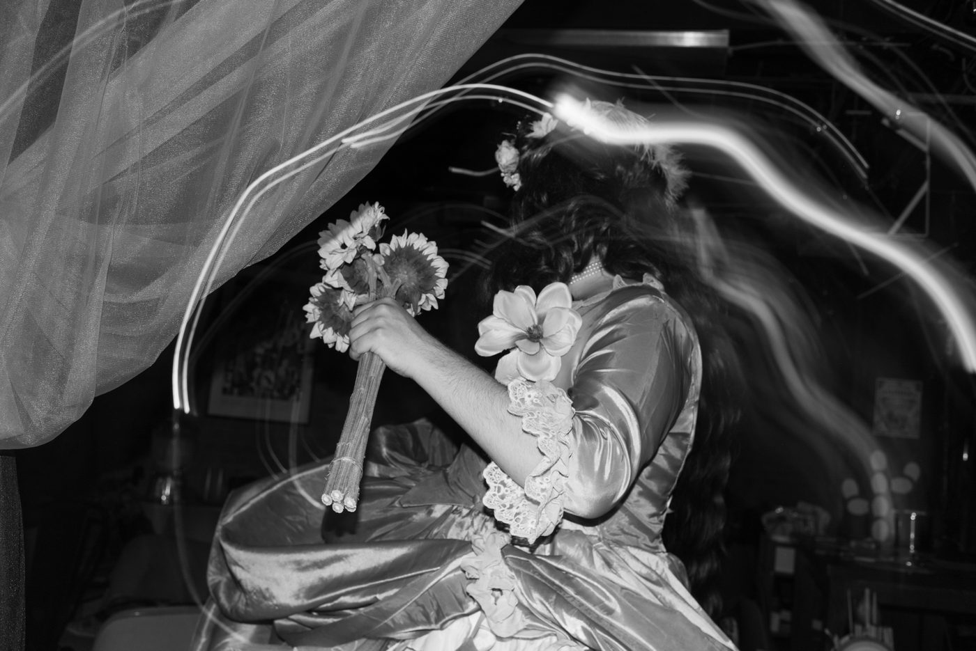A drag performer spins around in a motion blurred photo
