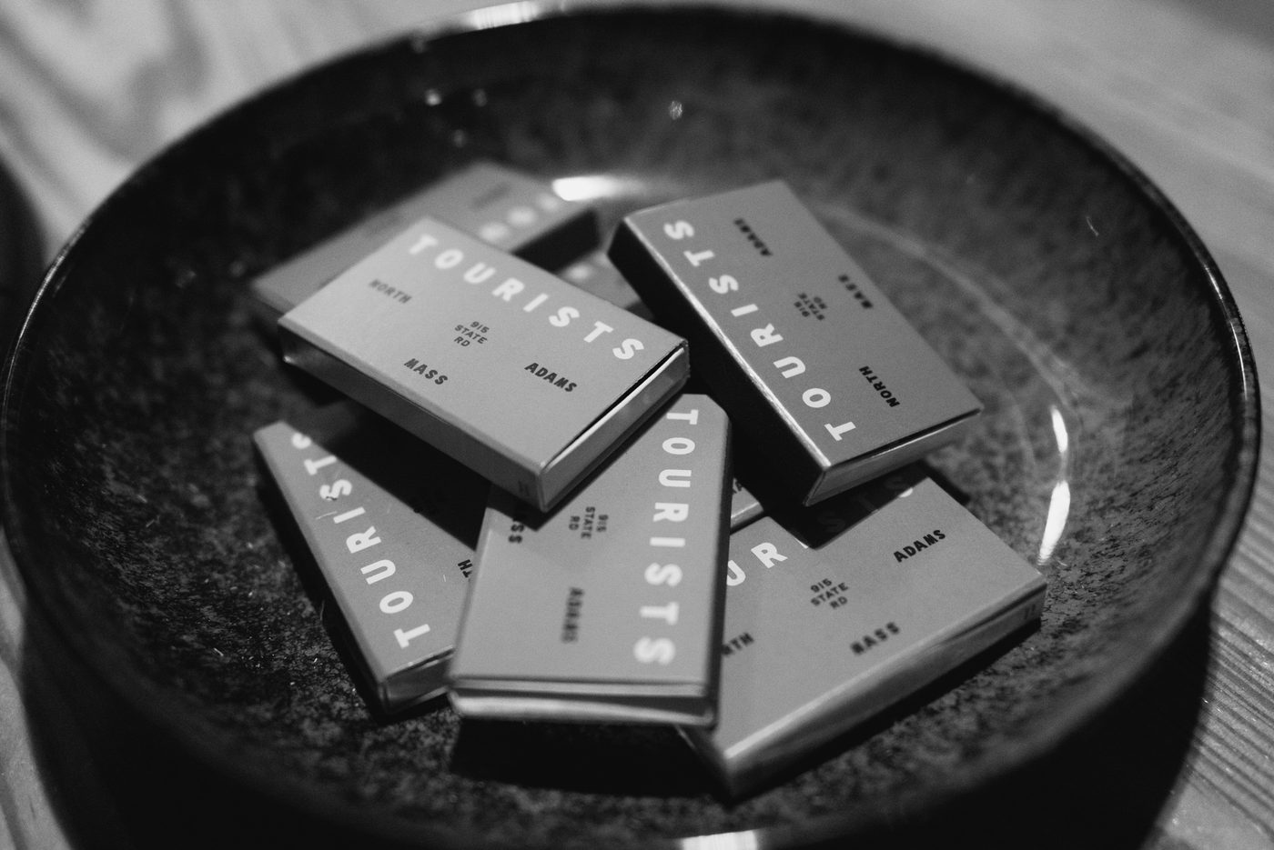 An ash tray full of match boxes with the TOURISTS logo